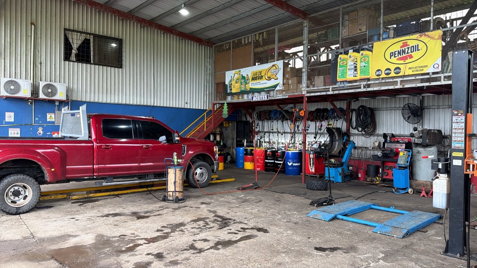 Interior del galerón con la pickup, el elevador y los tambores de aceite