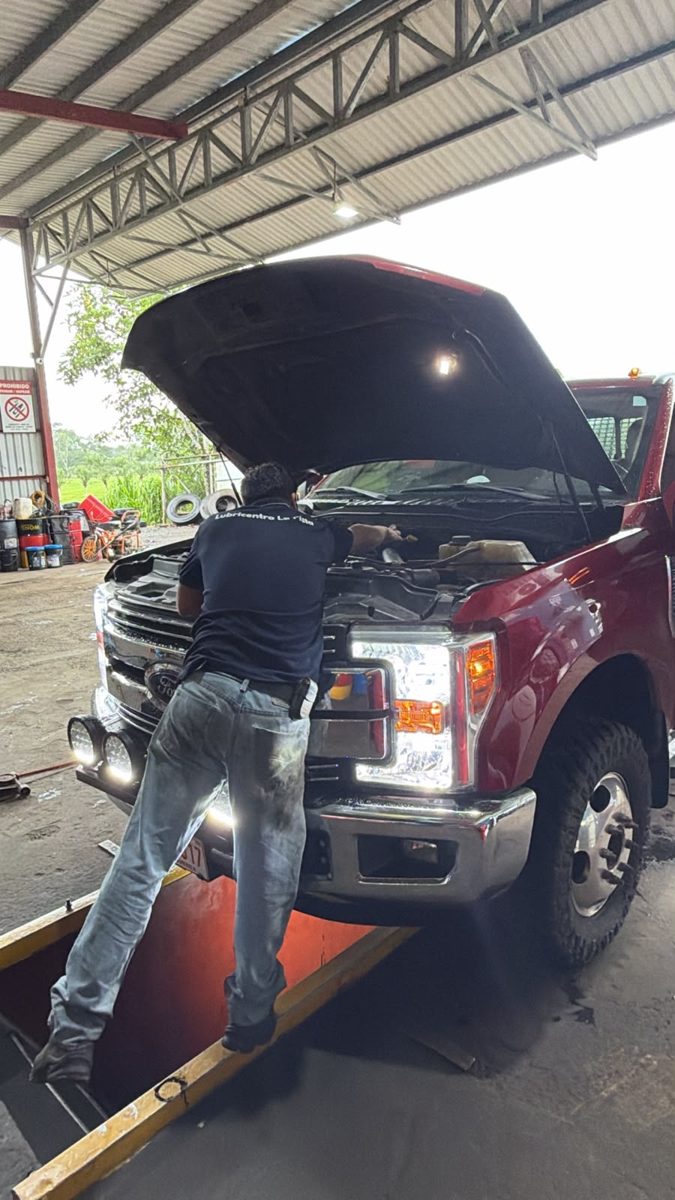 Mecánico revisando el motor de una pickup bajo el galerón
